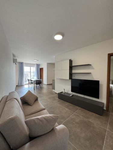 a living room with a couch and a flat screen tv at Serenity Escape 2 Bed with Patio in Taʼ Penza