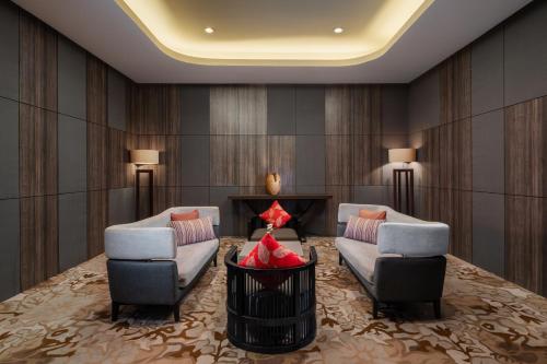 a lobby with two couches and a table and chairs at Melia Makassar in Makassar