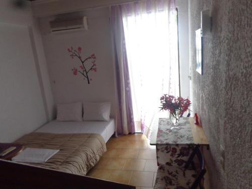 a small bedroom with a bed and a window at Angela Hotel in Agia Marina Aegina