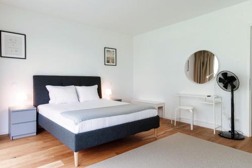 a bedroom with a bed and a lamp and a mirror at Residenza Ticino by Quokka 360 - Modern Oasis near Bellinzona in Bellinzona