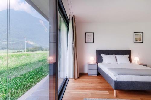 a bedroom with a bed and a large window at Residenza Ticino by Quokka 360 - Modern Oasis near Bellinzona in Bellinzona
