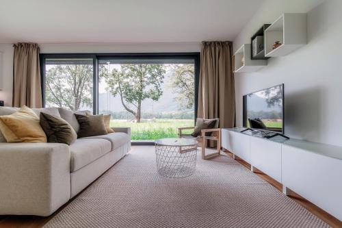 a living room with a couch and a large window at Residenza Ticino by Quokka 360 - Modern Oasis near Bellinzona in Bellinzona