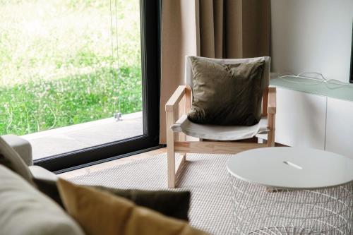 a living room with a chair and a table and a window at Residenza Ticino by Quokka 360 - Modern Oasis near Bellinzona in Bellinzona
