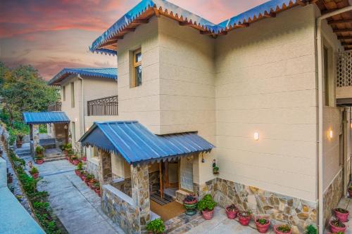 an aerial view of a house with a blue roof at SaffronStays Edelweiss Estate Amore in Chaubattia