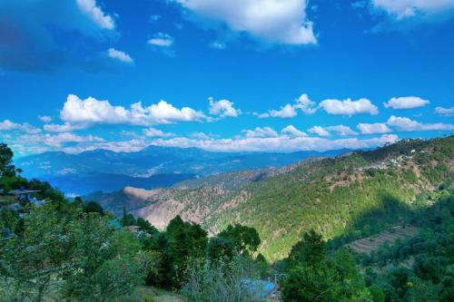 a view of the mountains from the top of a hill at SaffronStays Edelweiss Estate Amore in Chaubattia