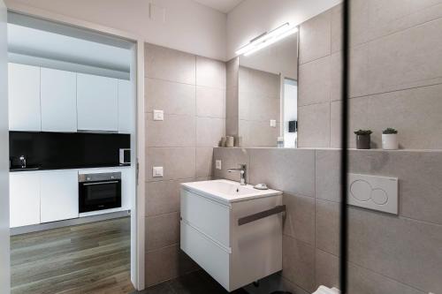 a bathroom with a sink and a mirror at Residenza Ticino by Quokka 360 - Modern Oasis near Bellinzona in Bellinzona