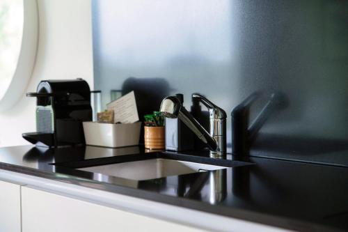a black counter top with a sink in a bathroom at Residenza Ticino by Quokka 360 - Modern Oasis near Bellinzona in Bellinzona