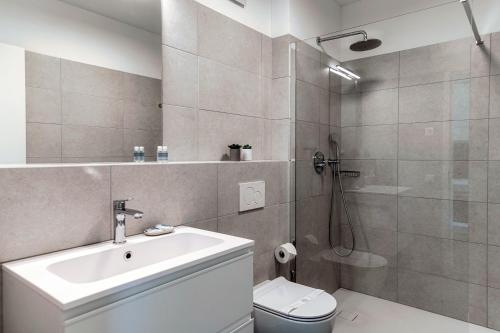 a bathroom with a sink and a toilet and a shower at Residenza Ticino by Quokka 360 - Modern Oasis near Bellinzona in Bellinzona