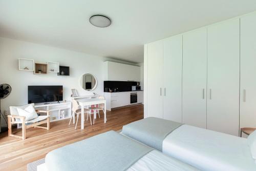 a bedroom with two beds and a desk and a tv at Residenza Ticino by Quokka 360 - Modern Oasis near Bellinzona in Bellinzona