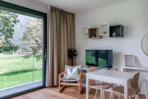 a dining room with a white table and a window at Residenza Ticino by Quokka 360 - Modern Oasis near Bellinzona in Bellinzona