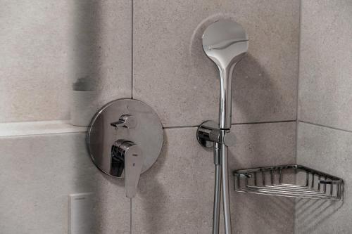 a shower with a shower head on a wall at Residenza Ticino by Quokka 360 - Modern Oasis near Bellinzona in Bellinzona