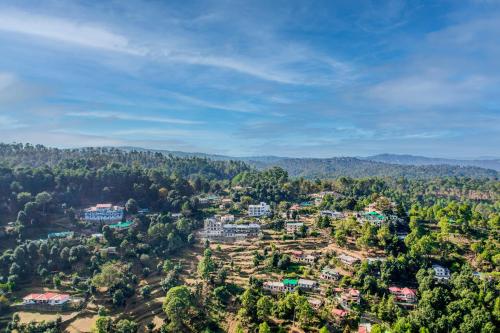 an aerial view of a village in the hills at SaffronStays Edelweiss Estate Amore in Chaubattia