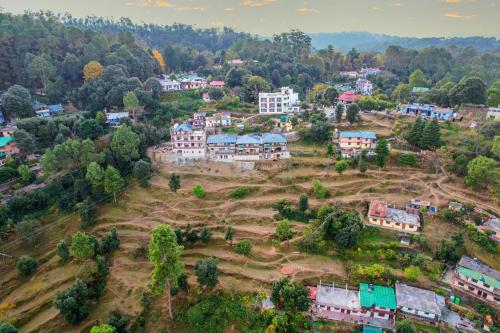 an aerial view of a town with houses and trees at SaffronStays Edelweiss Estate Amore in Chaubattia