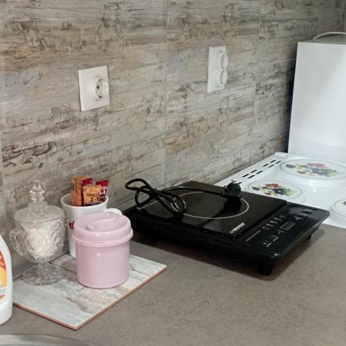 a kitchen counter with a stove top oven next to a microwave at Apartman Icić in Pirot