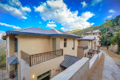 a house with a balcony with a roof at SaffronStays Edelweiss Estate Amore in Chaubattia