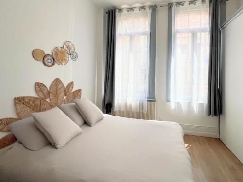 - un lit blanc avec des oreillers blancs dans une chambre dans l'établissement Maison Hypercentre avec jardin, idéale groupes, 5 chambres 5 salles de bain, à Saint-Omer