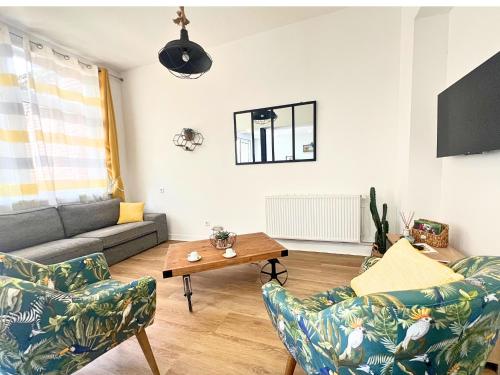 ein Wohnzimmer mit Couch und Tisch in der Unterkunft Le Repaire des 12- Hypercentre, jardin, idéale groupes, 5 chambres 5 salles de bain in Saint-Omer