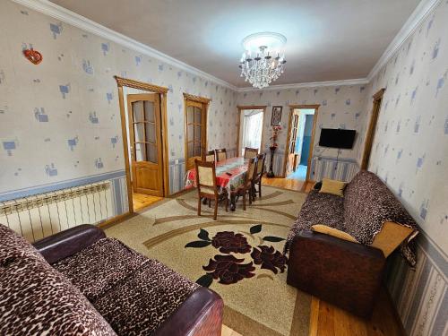 a living room with a couch and a table at Big yard white villa AYT in Gabala