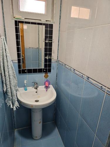 a blue tiled bathroom with a sink and a mirror at Big yard white villa AYT in Gabala