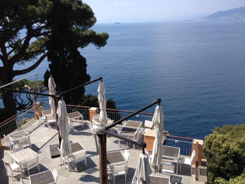 a group of chairs and umbrellas overlooking the ocean at Stella Maris Resort in Camogli