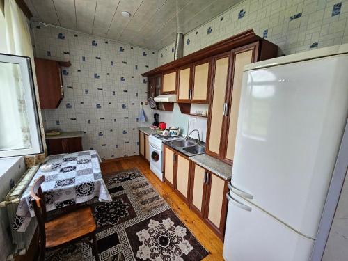 a kitchen with a refrigerator and a table in it at Big yard white villa AYT in Gabala