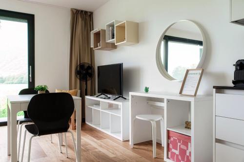 a living room with a desk and a mirror at Residenza Ticino by Quokka 360 - Modern Oasis near Bellinzona in Bellinzona