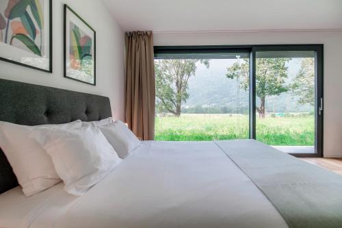 a bedroom with a large bed with a large window at Residenza Ticino by Quokka 360 - Modern Oasis near Bellinzona in Bellinzona