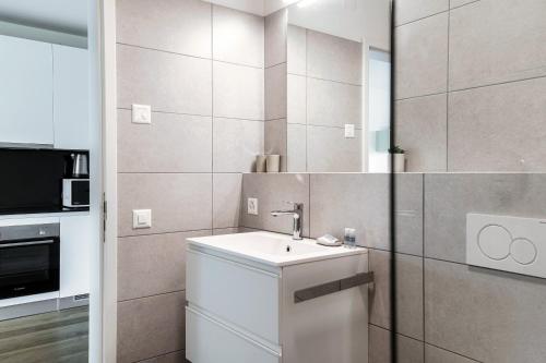 a small bathroom with a sink and a microwave at Residenza Ticino by Quokka 360 - Modern Oasis near Bellinzona in Bellinzona