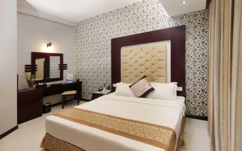 a bedroom with a bed and a desk in it at The Cox Today Limited in Cox's Bazar