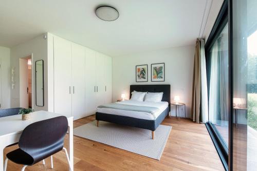 a bedroom with a bed and a table and a chair at Residenza Ticino by Quokka 360 - Modern Oasis near Bellinzona in Bellinzona