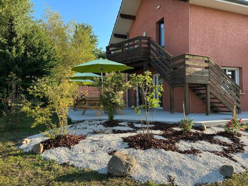 a patio with an umbrella and a table and bench at Gite Clé des Champs in Montenois