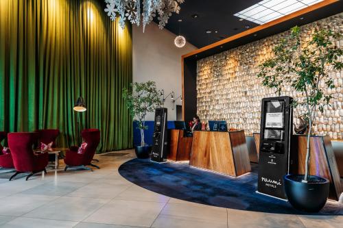 un hall d'entrée avec une caisse enregistreuse, des chaises et une table dans l'établissement Naumi Hotel Auckland Airport, à Auckland