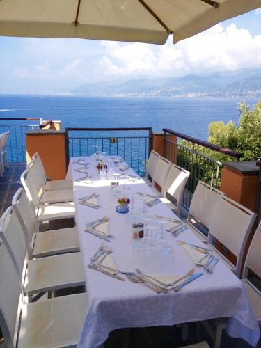 a table on a balcony with a view of the ocean at Stella Maris Resort in Camogli
