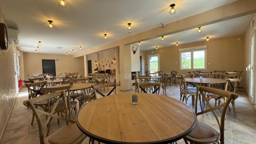 a dining room with wooden tables and chairs at Gite Clé des Champs in Montenois