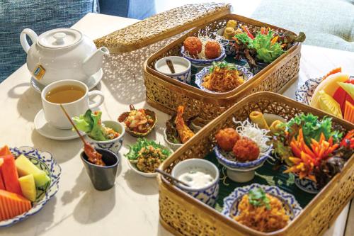 a table with several trays of food on it at Holiday Inn Bangkok by IHG in Bangkok