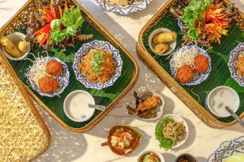 a table with three trays of food on it at Holiday Inn Bangkok by IHG in Bangkok
