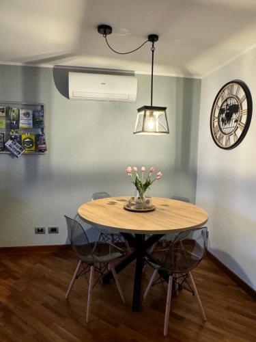 a dining room table with chairs and a clock on the wall at Formia Bellevue in Formia