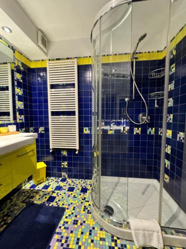a bathroom with blue and yellow tiles and a shower at Formia Bellevue in Formia