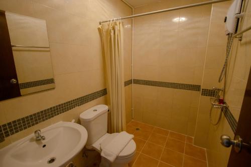 a bathroom with a shower and a toilet and a sink at RQ Phuket Kalim Beach Blue Horizon in Patong Beach