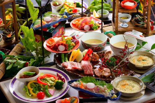 a table with plates of food and bowls of food at Hozantei in Minamioguni