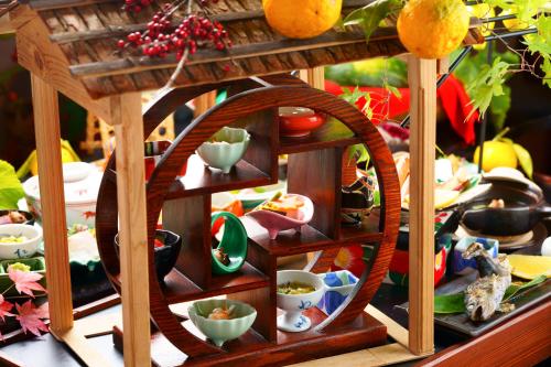 a table with a wooden shelf with bowls and dishes at Hozantei in Minamioguni