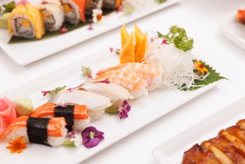 a variety of sushi dishes on plates on a table at Holiday Inn Bangkok by IHG in Bangkok