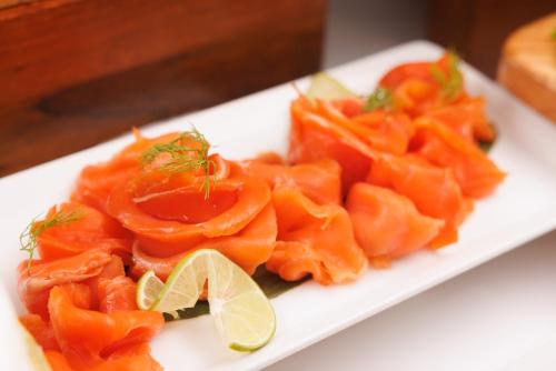 a white plate of food with orange peppers and lime slices at Holiday Inn Bangkok by IHG in Bangkok