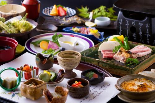 a table with plates of food and bowls of food at Hozantei in Minamioguni