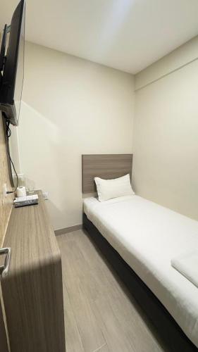 a bedroom with a bed and a flat screen tv at E Hotel Kulim in Kulim