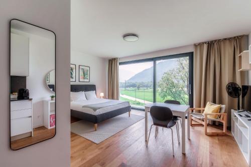a bedroom with a bed and a table and a mirror at Residenza Ticino by Quokka 360 - Modern Oasis near Bellinzona in Bellinzona