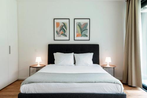 a bedroom with a large bed with two lamps at Residenza Ticino by Quokka 360 - Modern Oasis near Bellinzona in Bellinzona