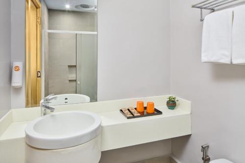 a white bathroom with a toilet and a sink at Go Hotels Plus Bacolod - Newly Renovated in Bacolod
