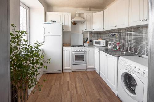 a kitchen with white appliances and a white refrigerator at Apart-Comfort Vatican in Yaroslavl