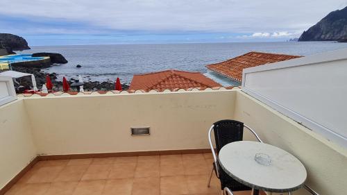 a balcony with a table and a view of the ocean at Hotel Costa Linda in Porto da Cruz